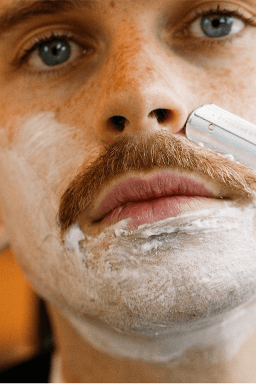 Close up of man shaving a moustache