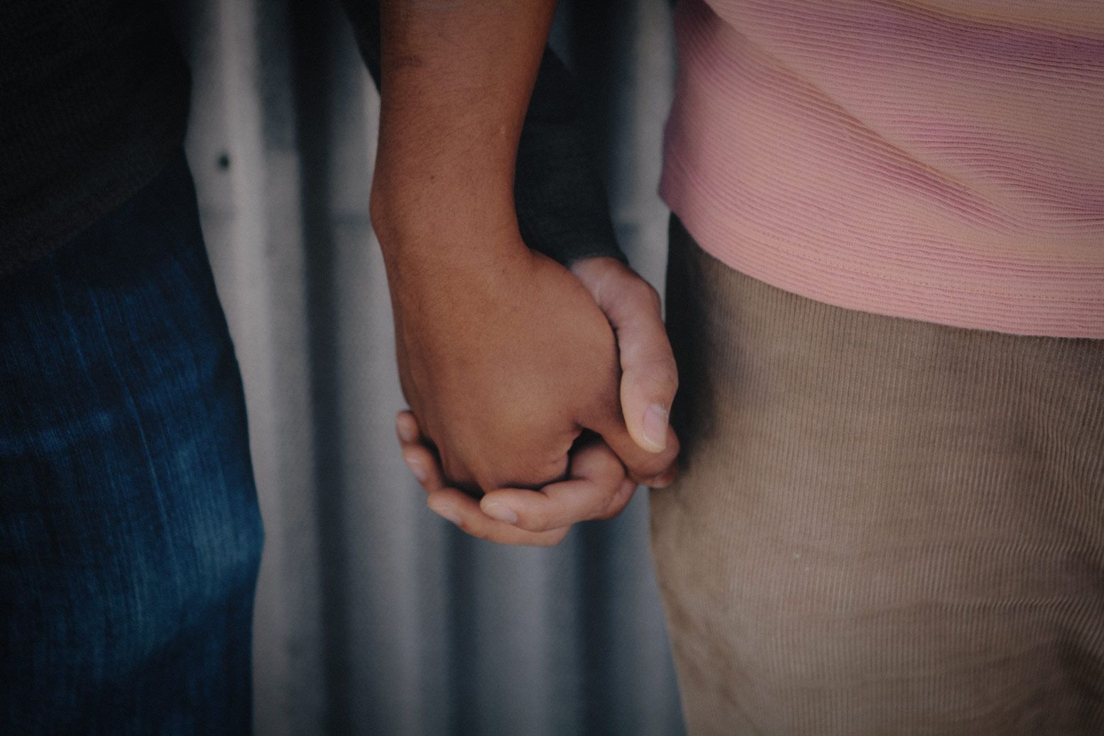 Close up of two men holding hands