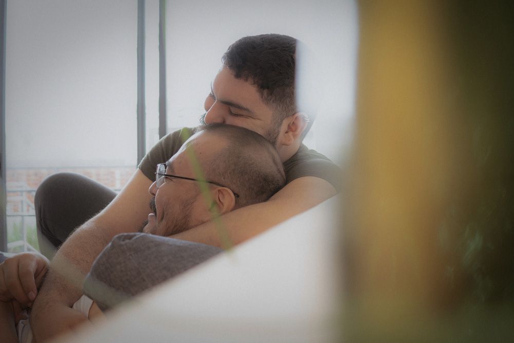 Two men hugging each other on the couch