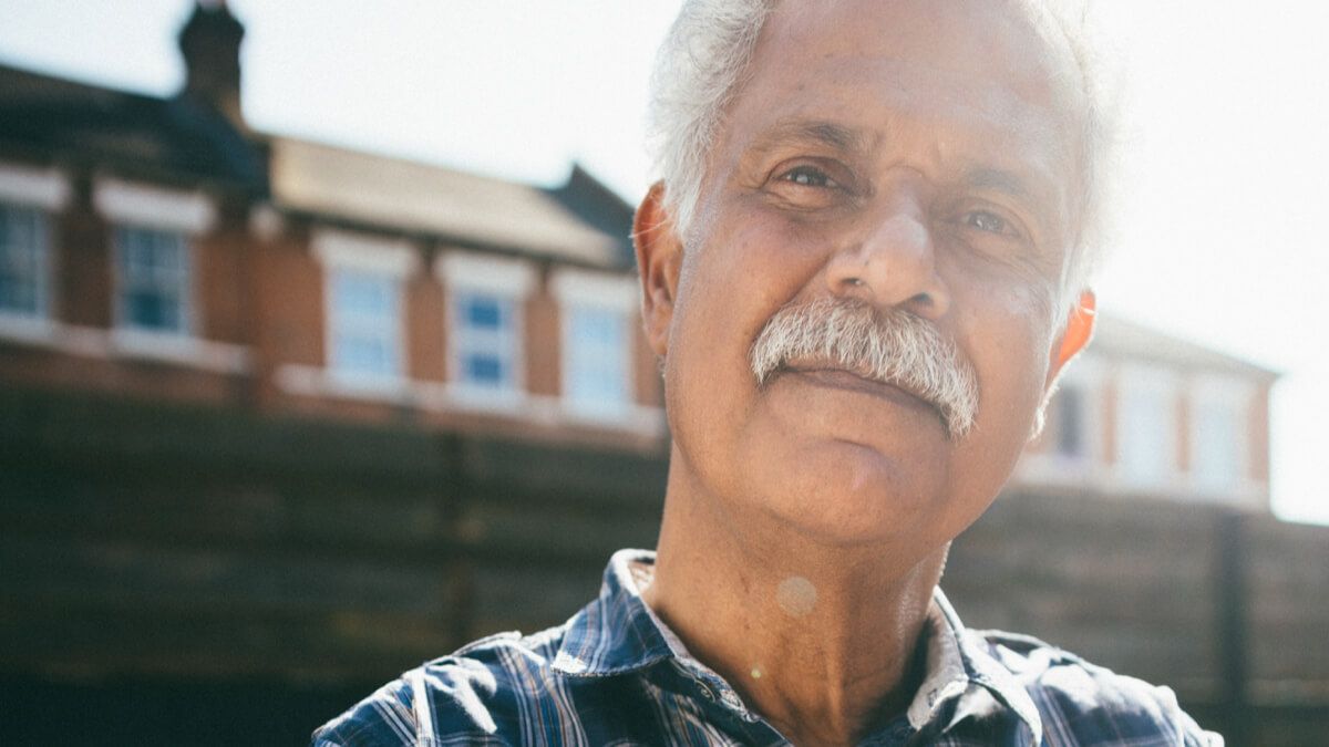 Close up of older man with moustache standing outside