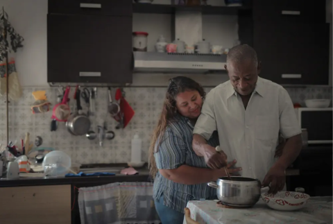 Black man and woman cooking together in the kitchen