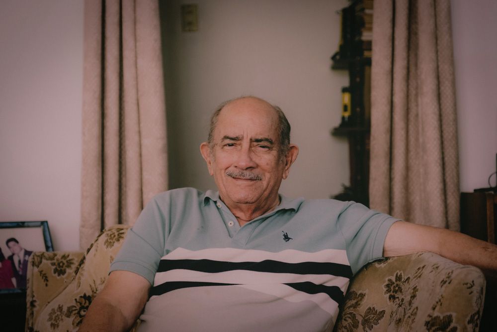 Close up of older man smiling from an armchair