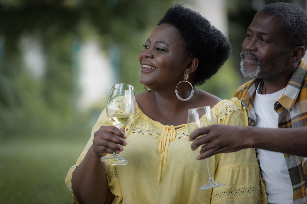 Black man and woman drinking wine together outdoors